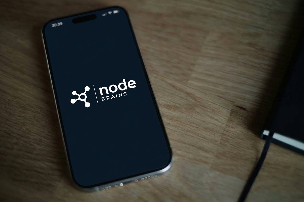 A phone on a desk showing the nodeBrains mark